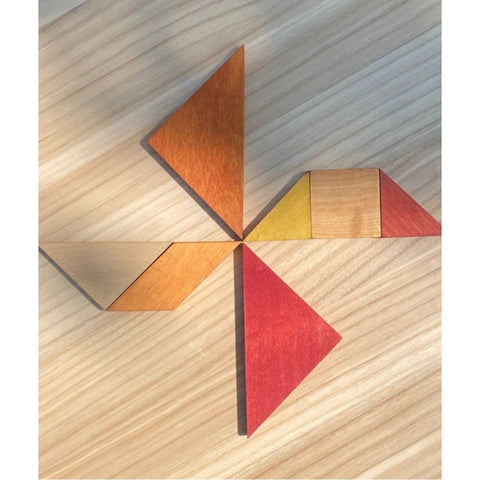 5. Wooden Story tangram pieces forming a windmill shape on a wooden surface