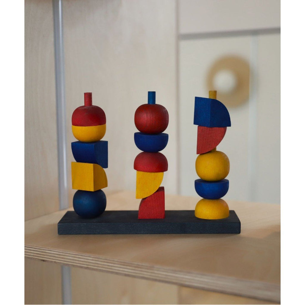 1. Wooden stacking toy with colorful geometric shapes on a shelf, natural setting