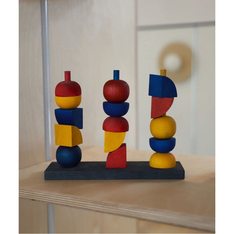 1. Wooden stacking toy with colorful geometric shapes on a shelf, natural setting