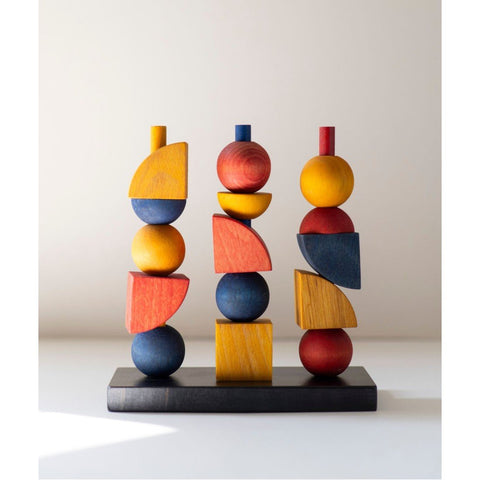 2. Bauhaus-inspired wooden stacking toy with colorful geometric shapes on a black base, studio setting