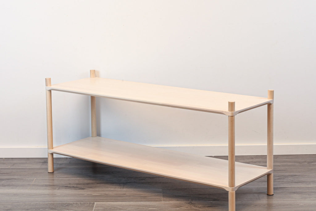2. Studio shot of Montessori-inspired wooden shelving unit with two shelves, made from natural birch wood, on a wooden floor