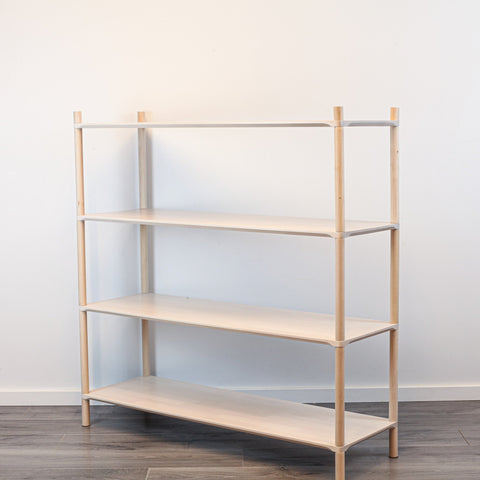 2. Side view of Montessori-inspired wooden shelving unit with four shelves, made from natural birch wood, on a wooden floor