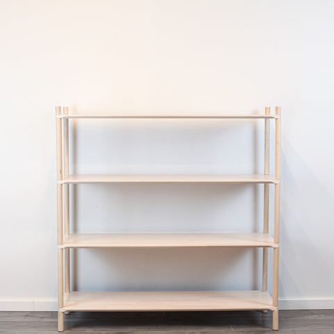 3. Front view of Montessori-inspired wooden shelving unit with four shelves, crafted from natural birch wood, against a white wall