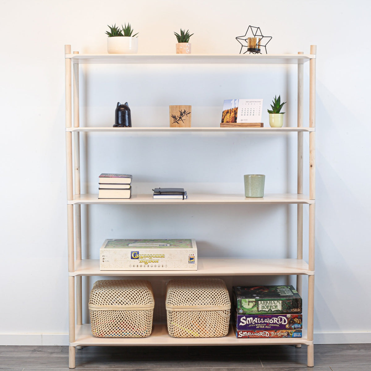1. Montessori-inspired wooden shelving unit with five shelves, decorated with books, plants, and baskets, against a white wall