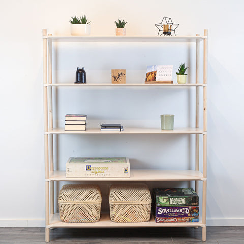 1. Montessori-inspired wooden shelving unit with five shelves, decorated with books, plants, and baskets, against a white wall
