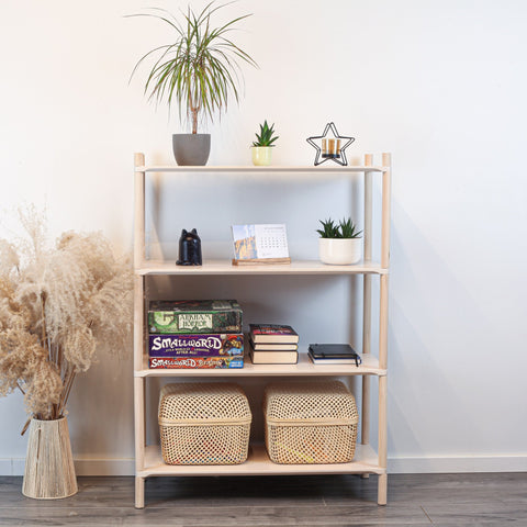 1. Montessori-inspired wooden shelving unit with four shelves, decorated with plants, books, and baskets, in a home setting