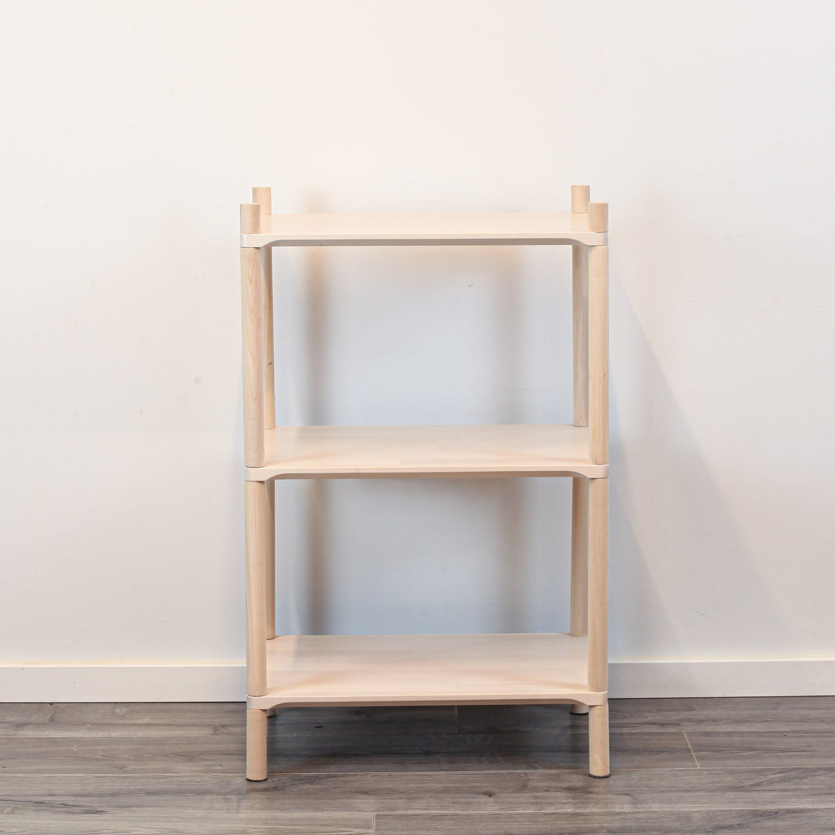 2. Front view of Montessori-inspired wooden shelving unit with three shelves, made from natural birch wood, against a plain white wall