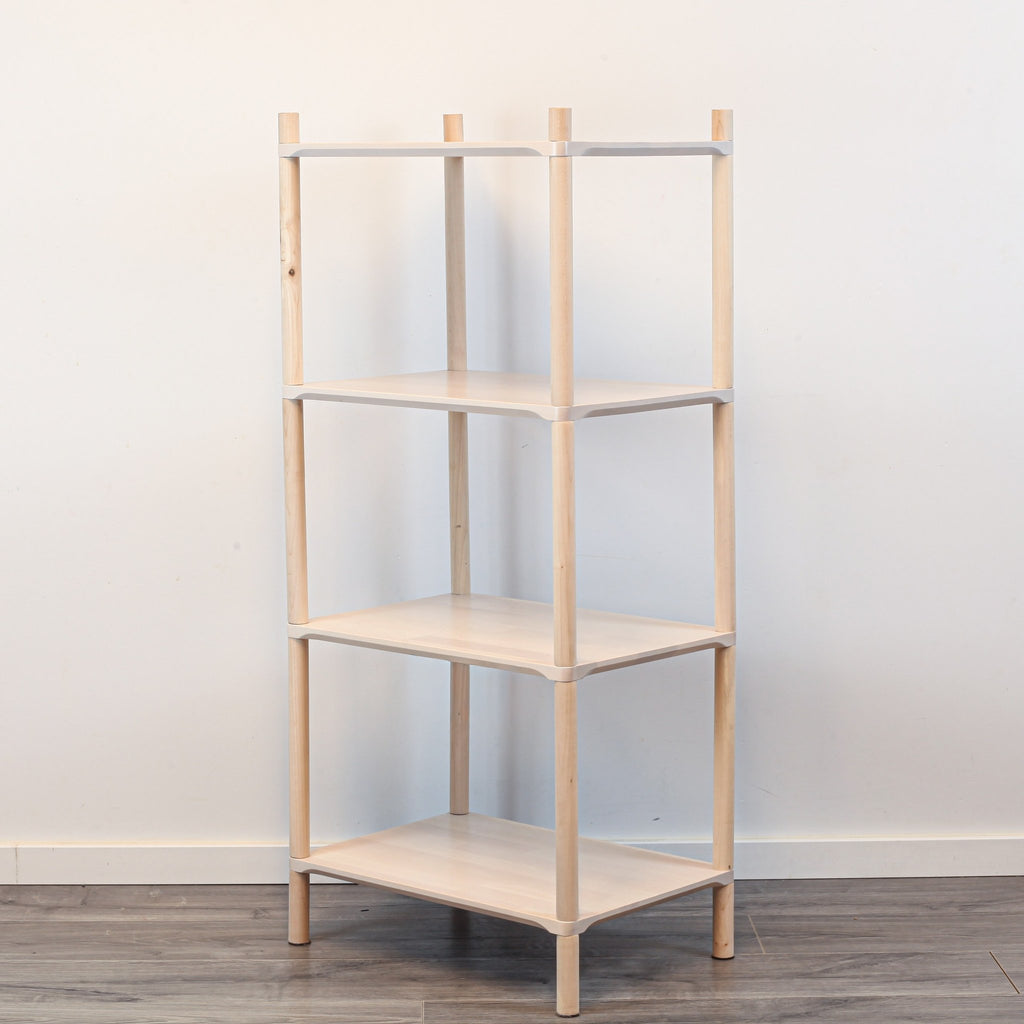 2. Studio shot of Montessori-inspired wooden shelving unit with four shelves, made from natural birch wood, shown at an angle against a plain white background