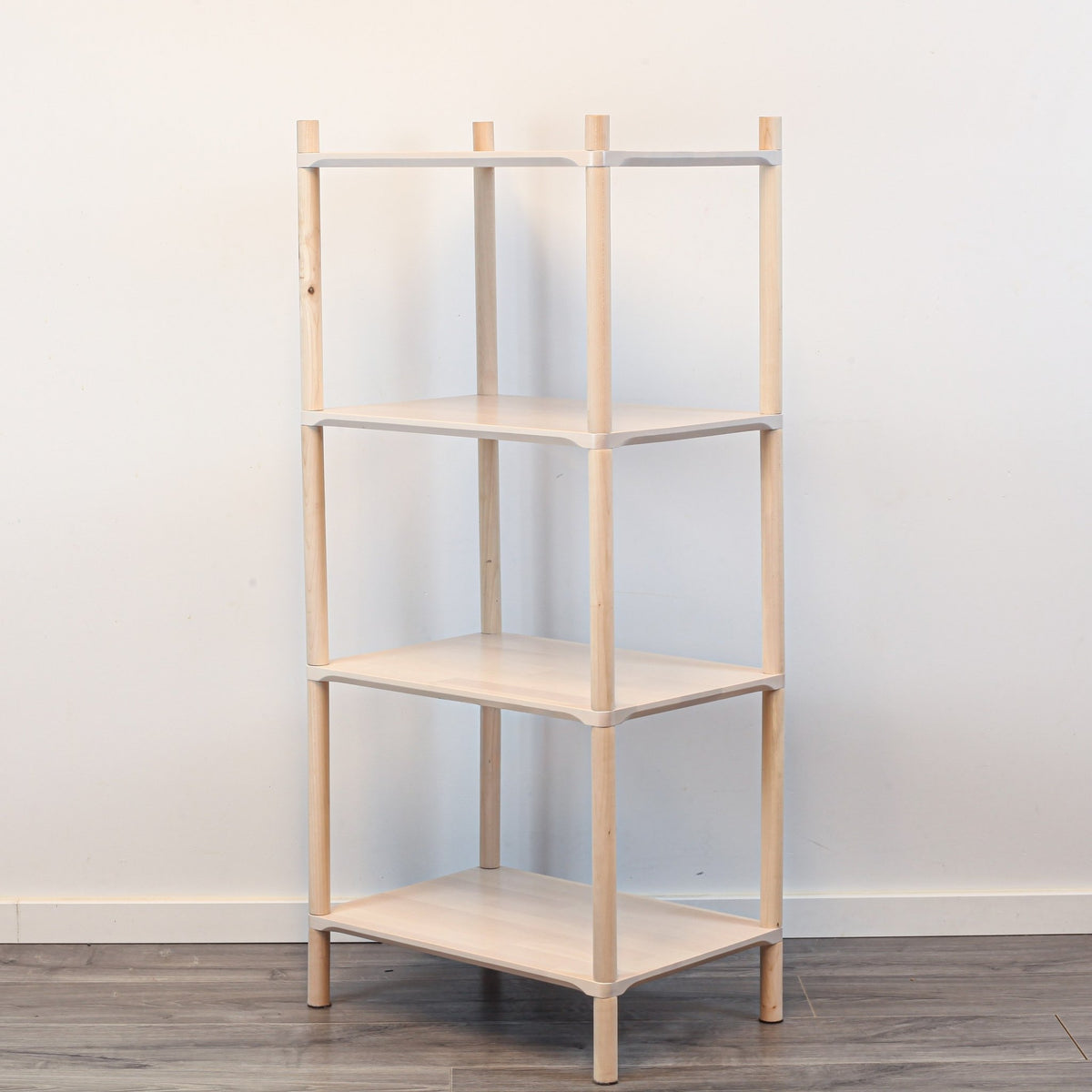 2. Studio shot of Montessori-inspired wooden shelving unit with four shelves, made from natural birch wood, shown at an angle against a plain white background