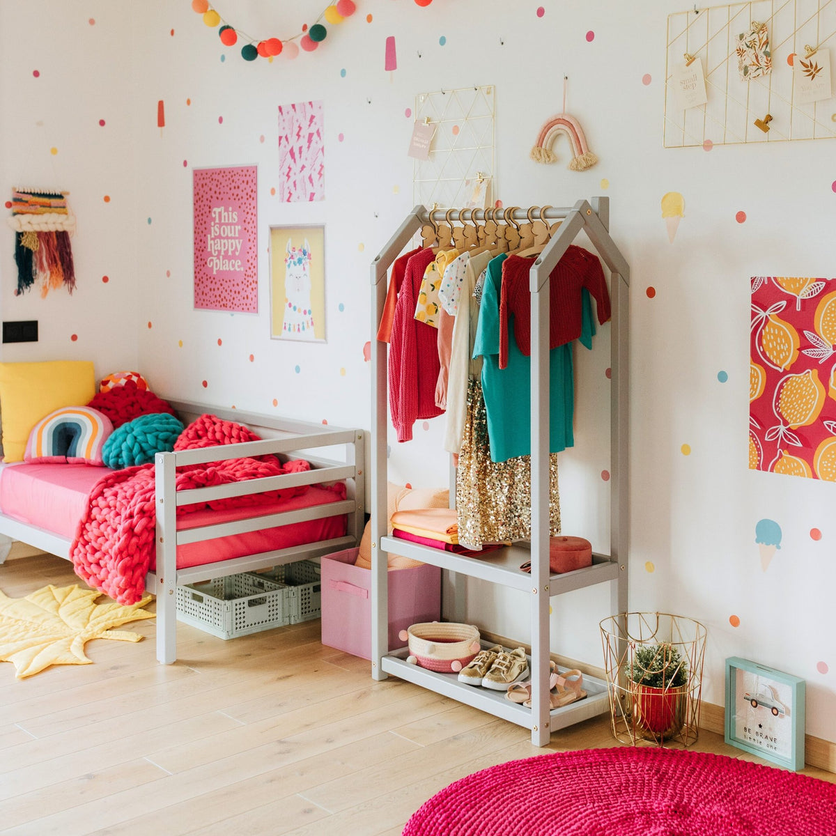1. Grey house-shaped clothing rack with colorful children's clothes in a decorated kids' room