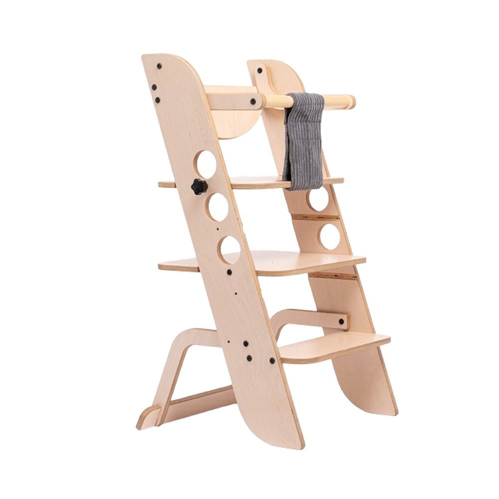 1. Wooden Montessori learning tower with adjustable height and support bar, shown in a kitchen setting