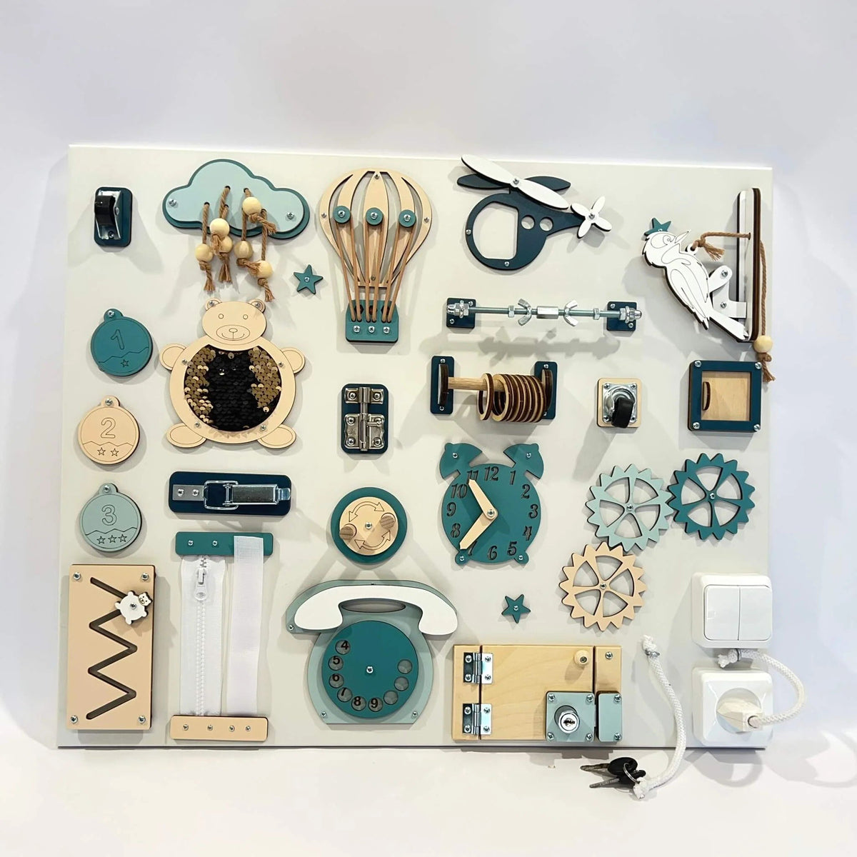 1. Montessori busy board with teal and beige elements on white background, featuring interactive components like gears, switches, and a clock, designed for skill building.