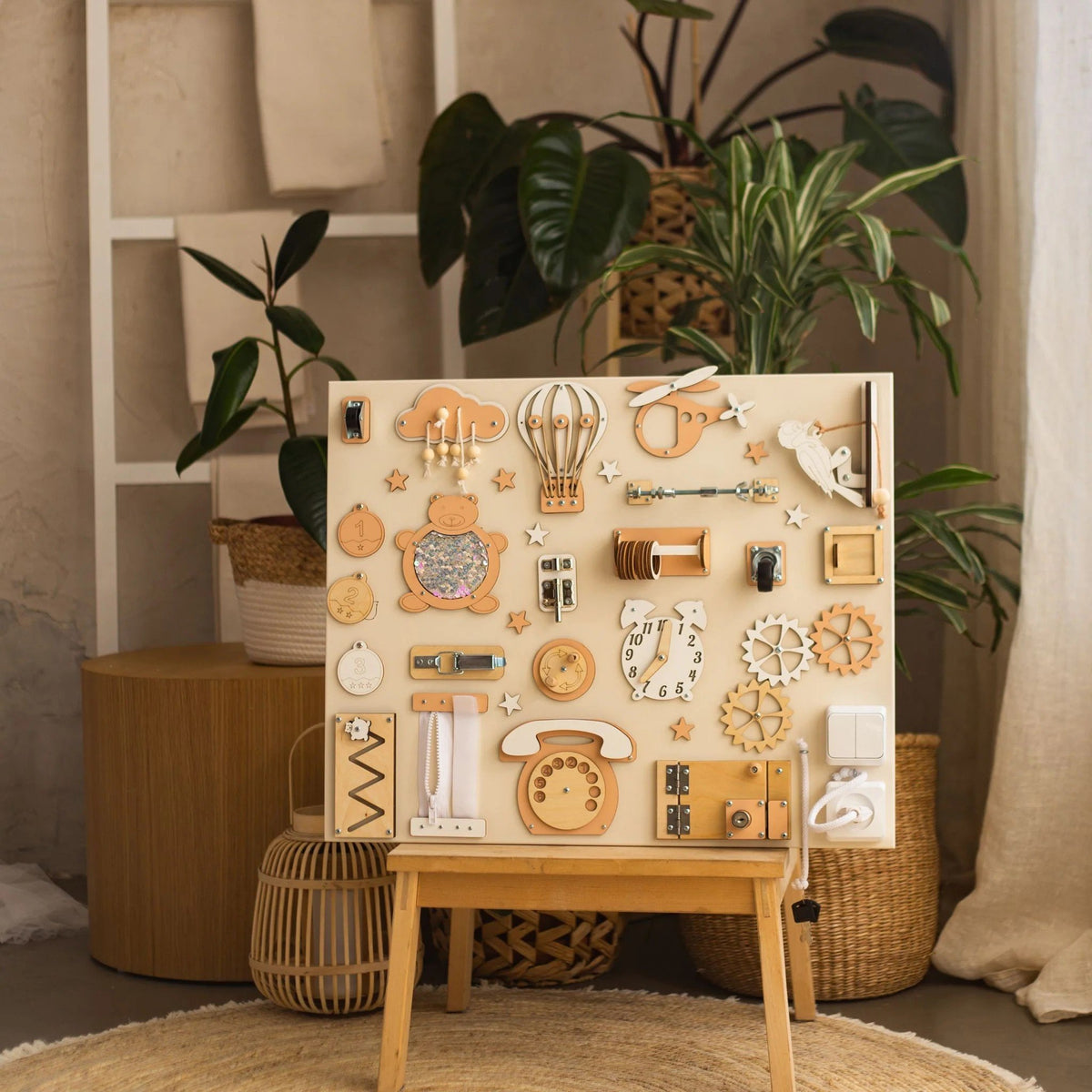 1. Montessori busy board with beige and orange elements on an easel in a room with plants, designed for interactive play.