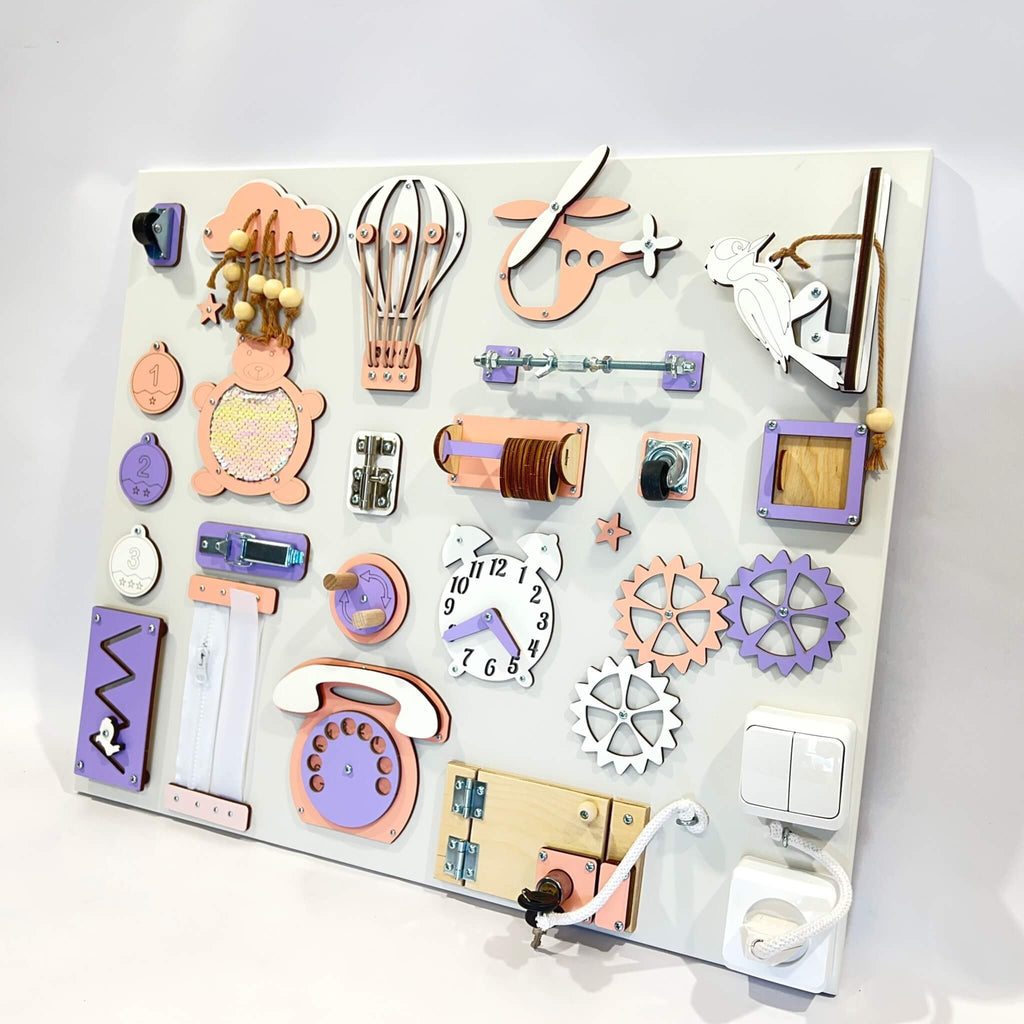 2. Montessori busy board with purple and orange elements on white background, featuring interactive components like gears and a clock.