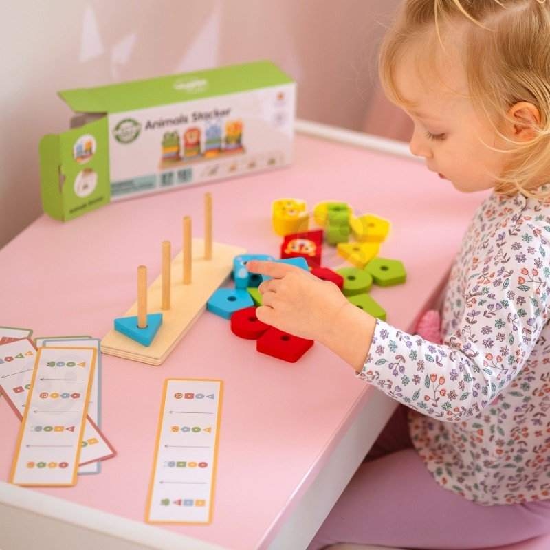 7. Child playing with colorful blocks and pattern cards on Montessori puzzle pyramid on pink table