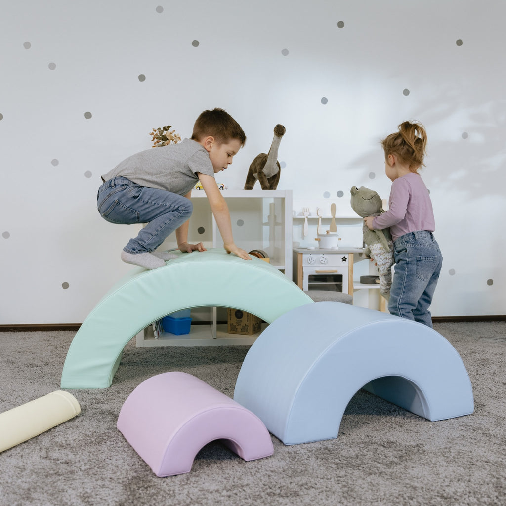 6. Boy and girl playing on pastel rainbow soft play set in playroom