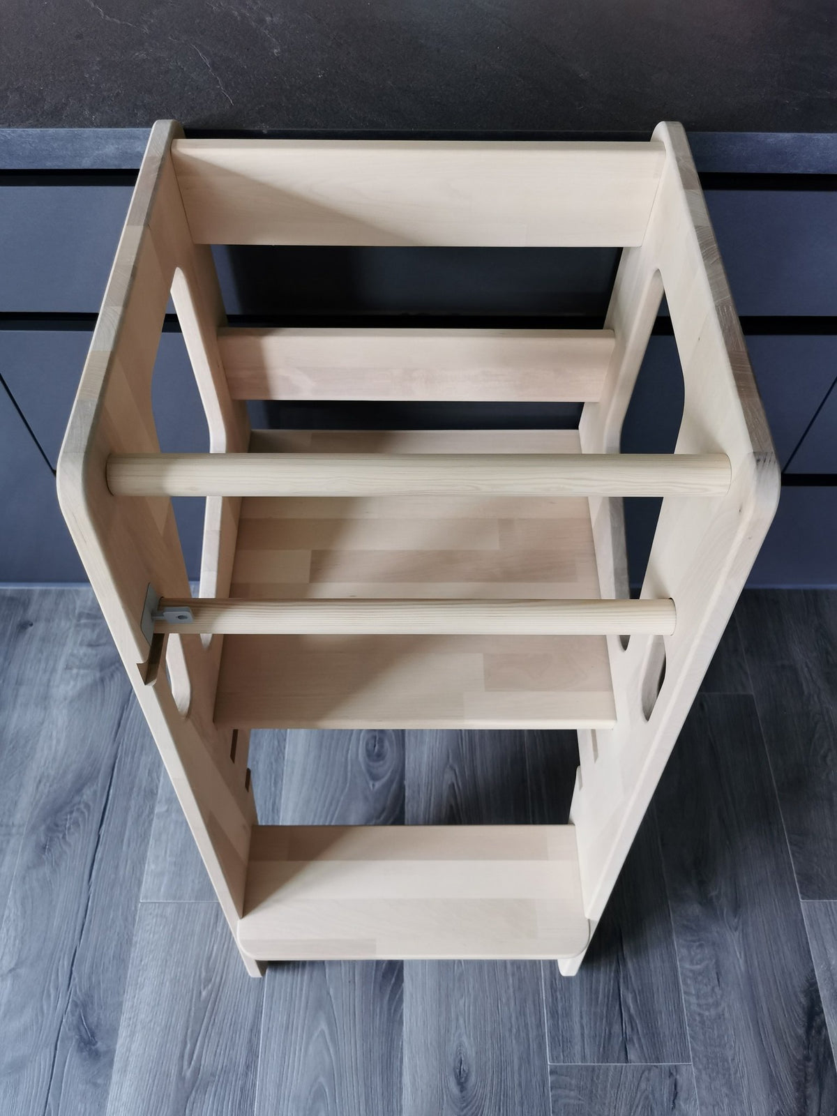 2. Top view of natural birch Montessori Tower Safety+ showing platform and safety bars, emphasizing its sturdy construction