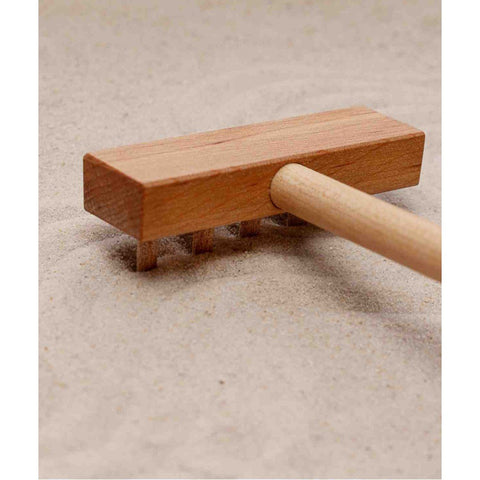 3. Close-up of wooden tool on sand in Montessori tray, highlighting texture and craftsmanship