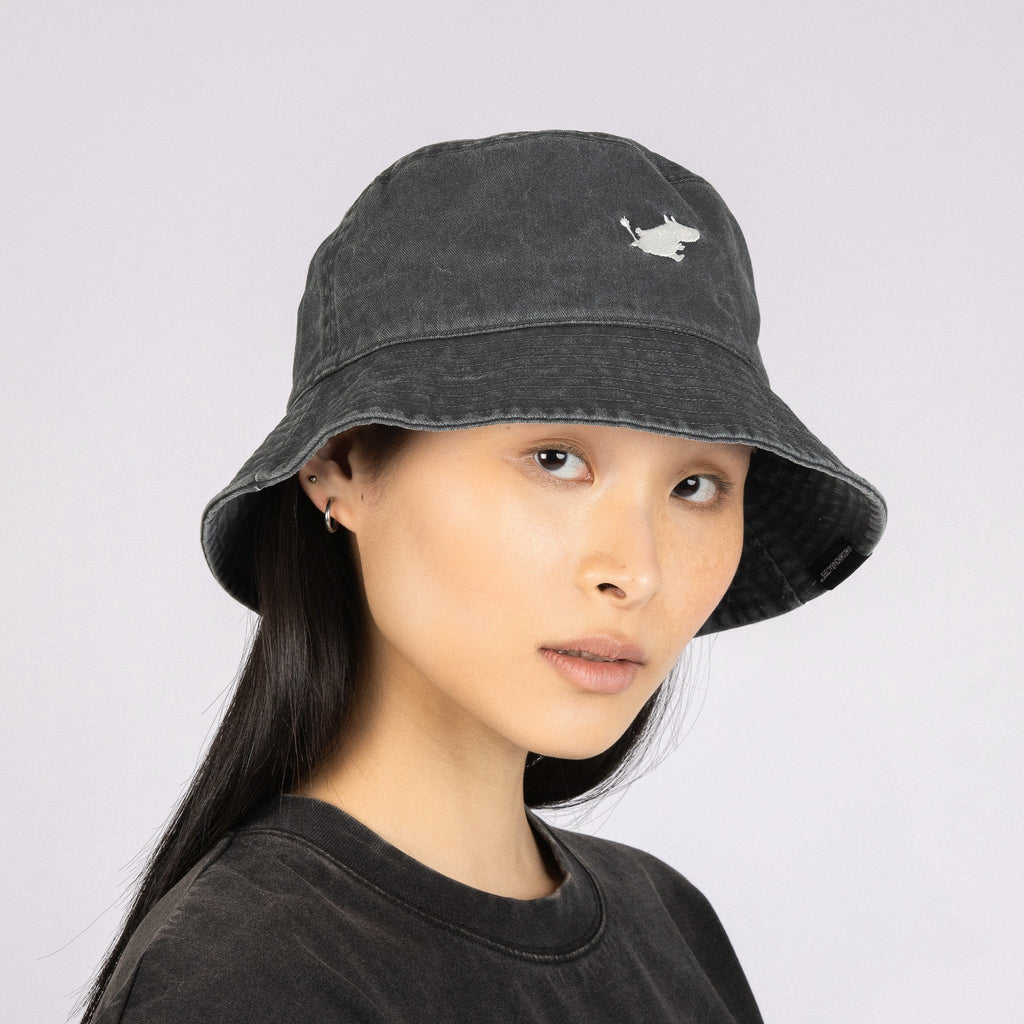 1. Women's black washed denim Moomin bucket hat by NordicBuddies, worn by model in studio