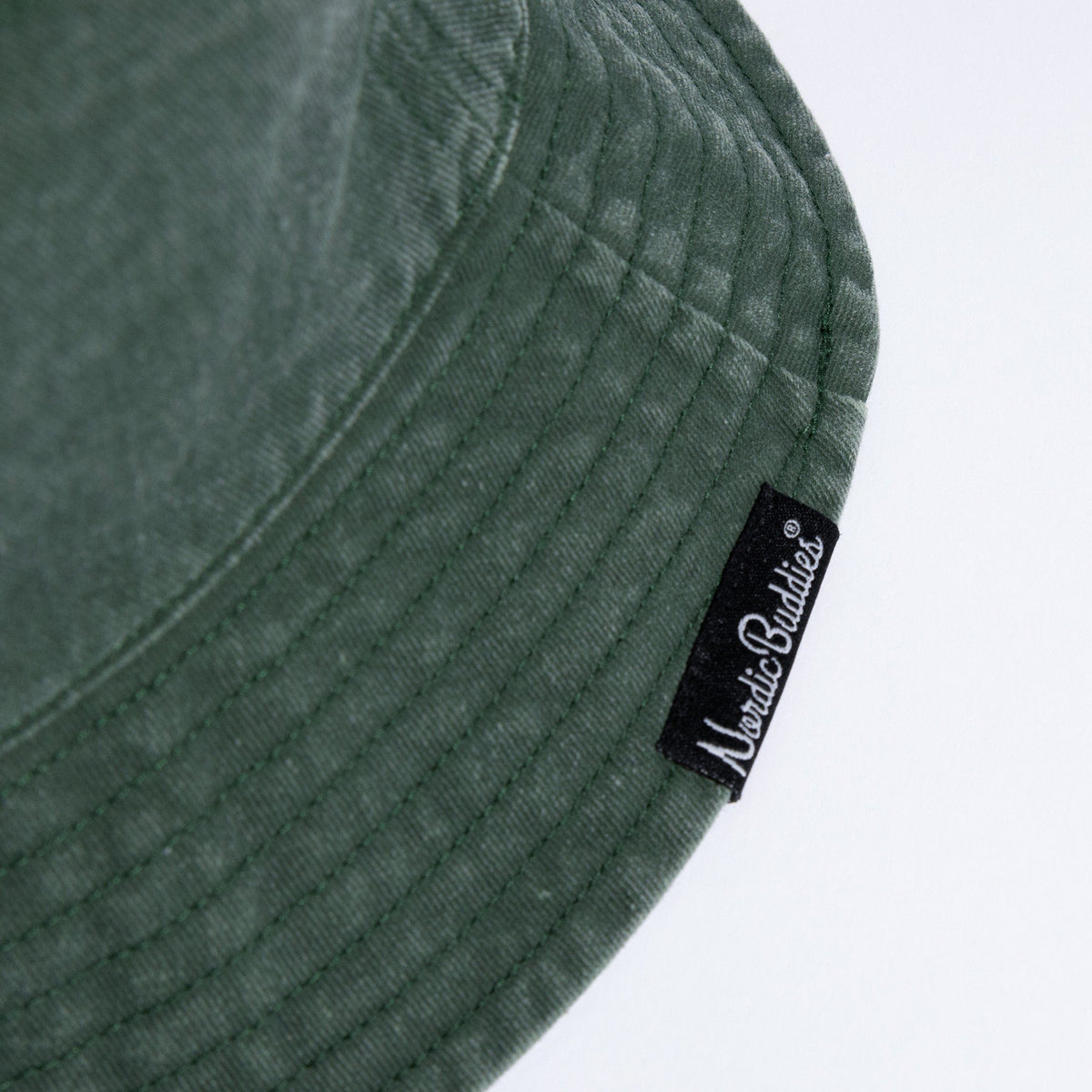 4. Close-up of NordicBuddies label on green washed denim bucket hat brim