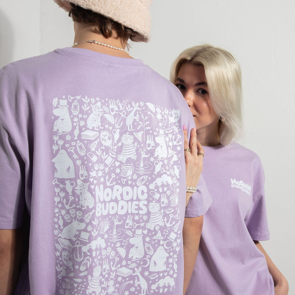 1. Two models wearing lilac Moomin unisex t-shirts with Nordic Buddies print, male model facing back, female model facing front, in casual setting