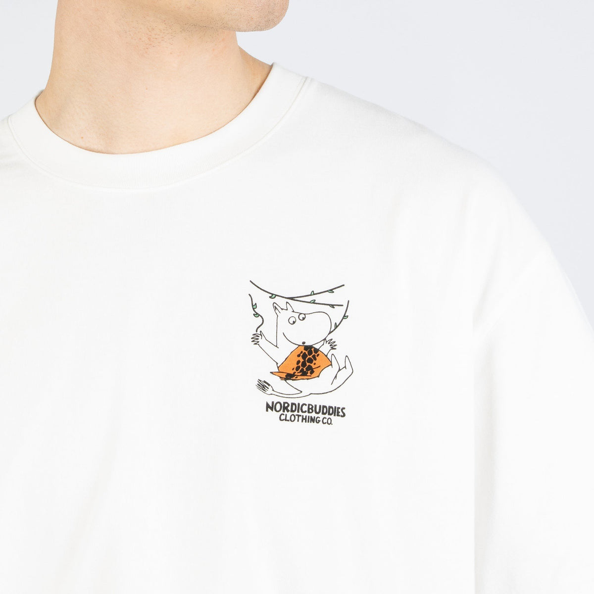 6. Close-up of small Moomin logo on front of white t-shirt by NordicBuddies