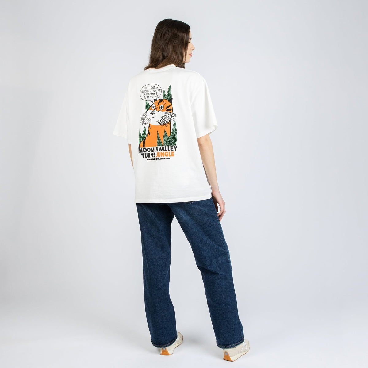 3. Female model wearing unisex white Moomin Jungle t-shirt, showing back design in studio
