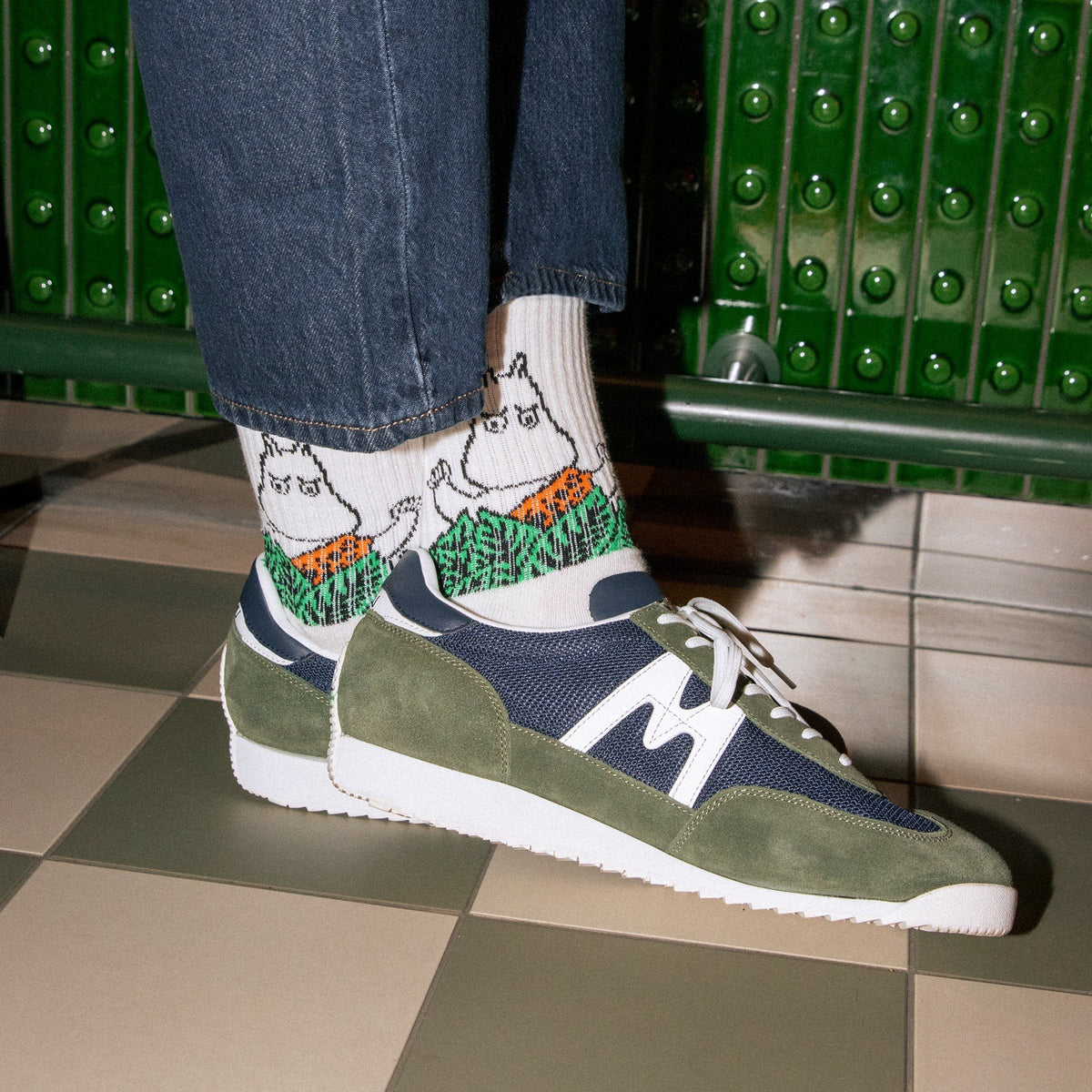 1. Men's Moomin Jungle retro socks in white worn with sneakers, showcasing playful jungle design in lifestyle setting