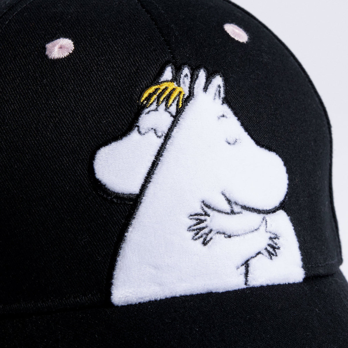 2. Close-up of Moomin Love kids' cap showing embroidered Moomin characters on black cotton