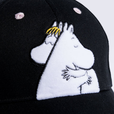 2. Close-up of Moomin Love kids' cap showing embroidered Moomin characters on black cotton