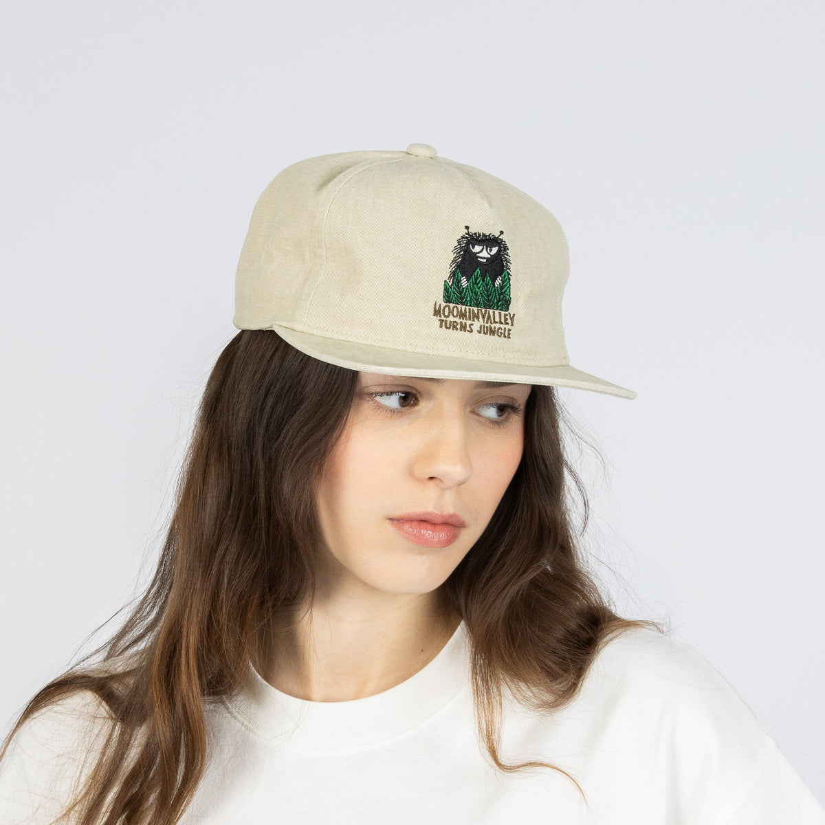 2. Female model wearing Moomin by NordicBuddies denim cap in beige, shown from front in studio