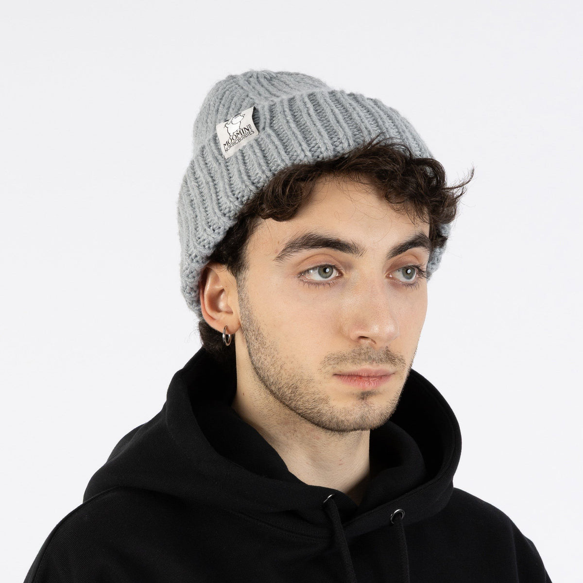 1. Man wearing grey Moominpappa chunky beanie with ribbed texture, shown from front, paired with black hoodie