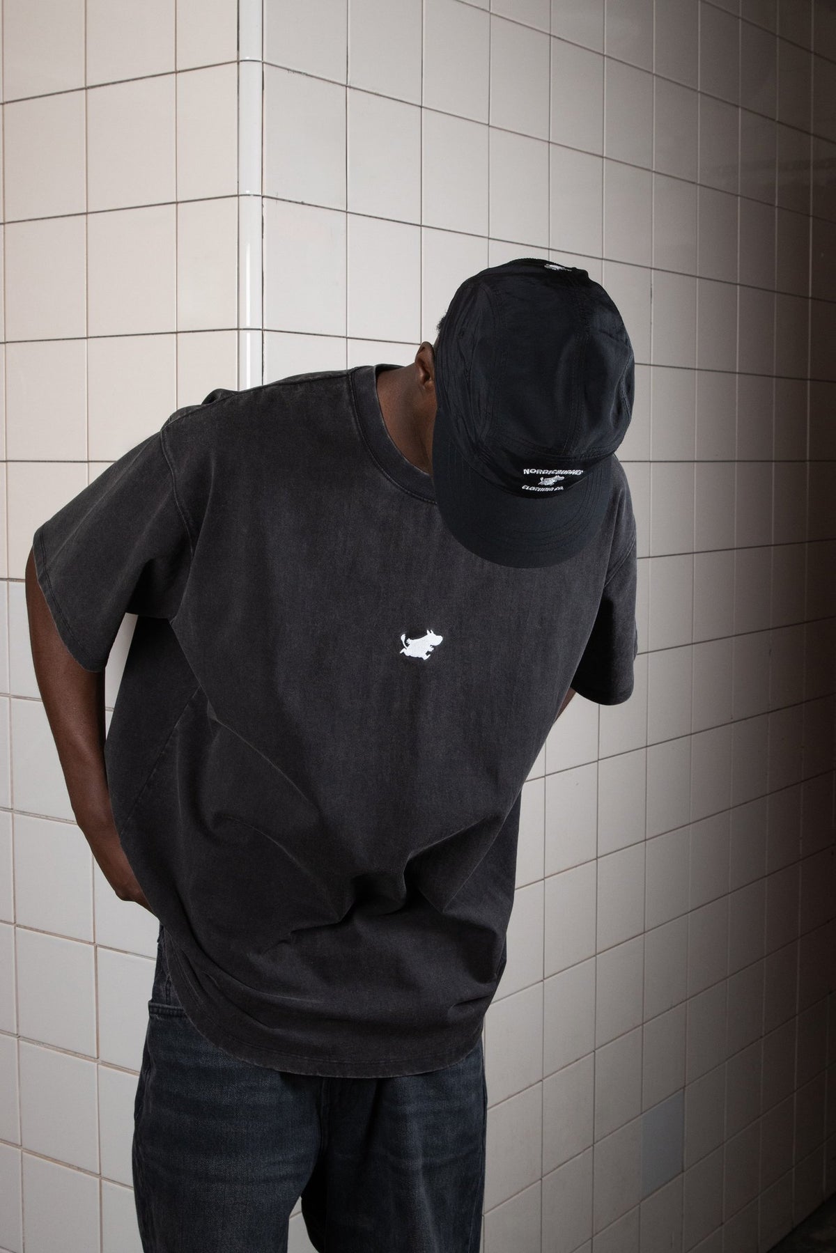 1. Unisex black Moomintroll Adventure 5-panel cap worn by male model in urban setting