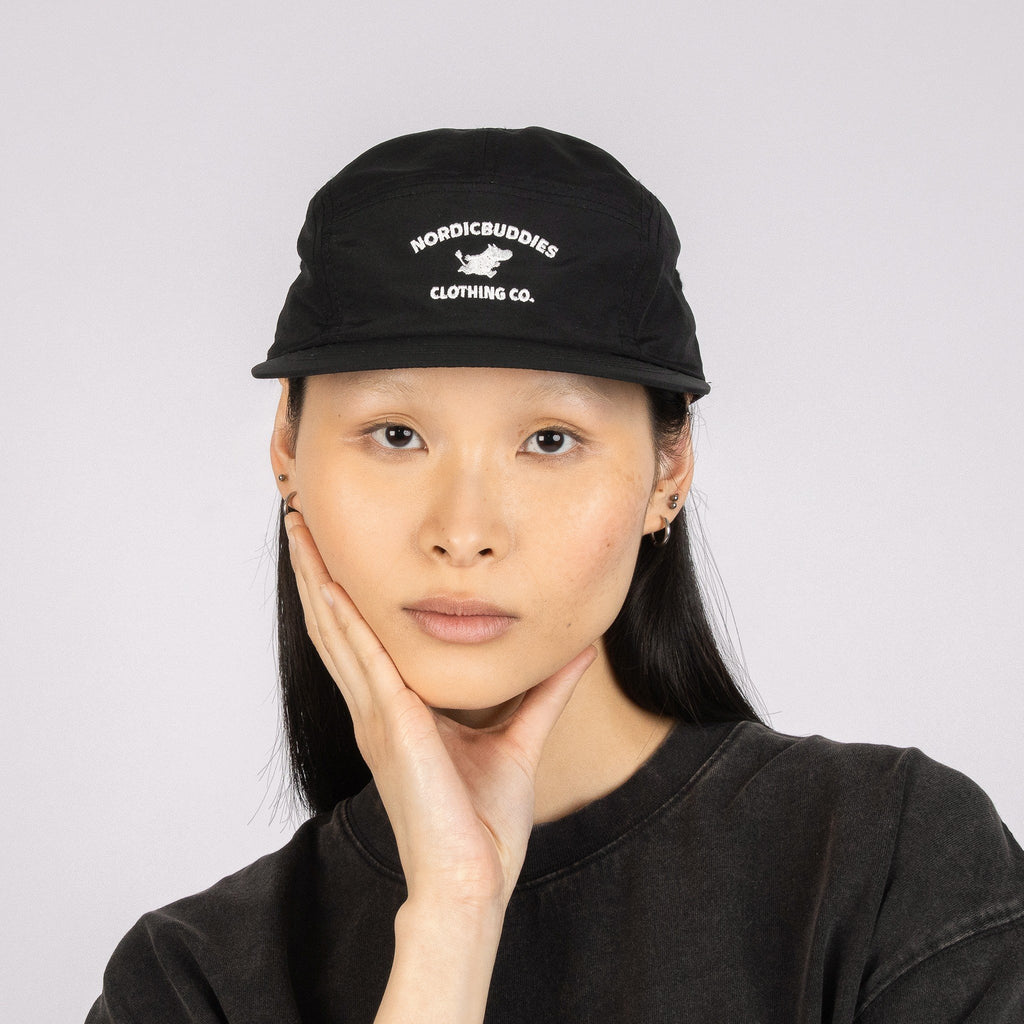 2. Unisex black Moomintroll Adventure 5-panel cap worn by female model in studio