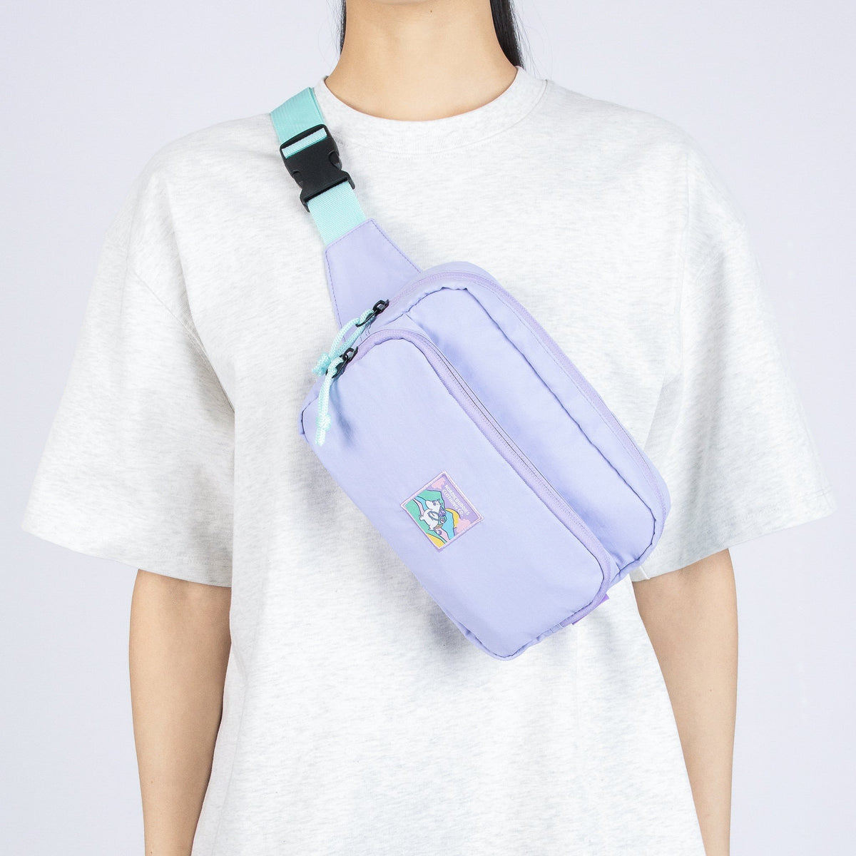 1. Woman wearing lavender waist bag with Moomin patch across chest