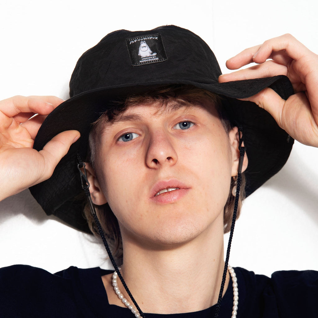 2. Close-up of male model wearing Moomintroll Brimmer Hat in black, highlighting Moomin logo