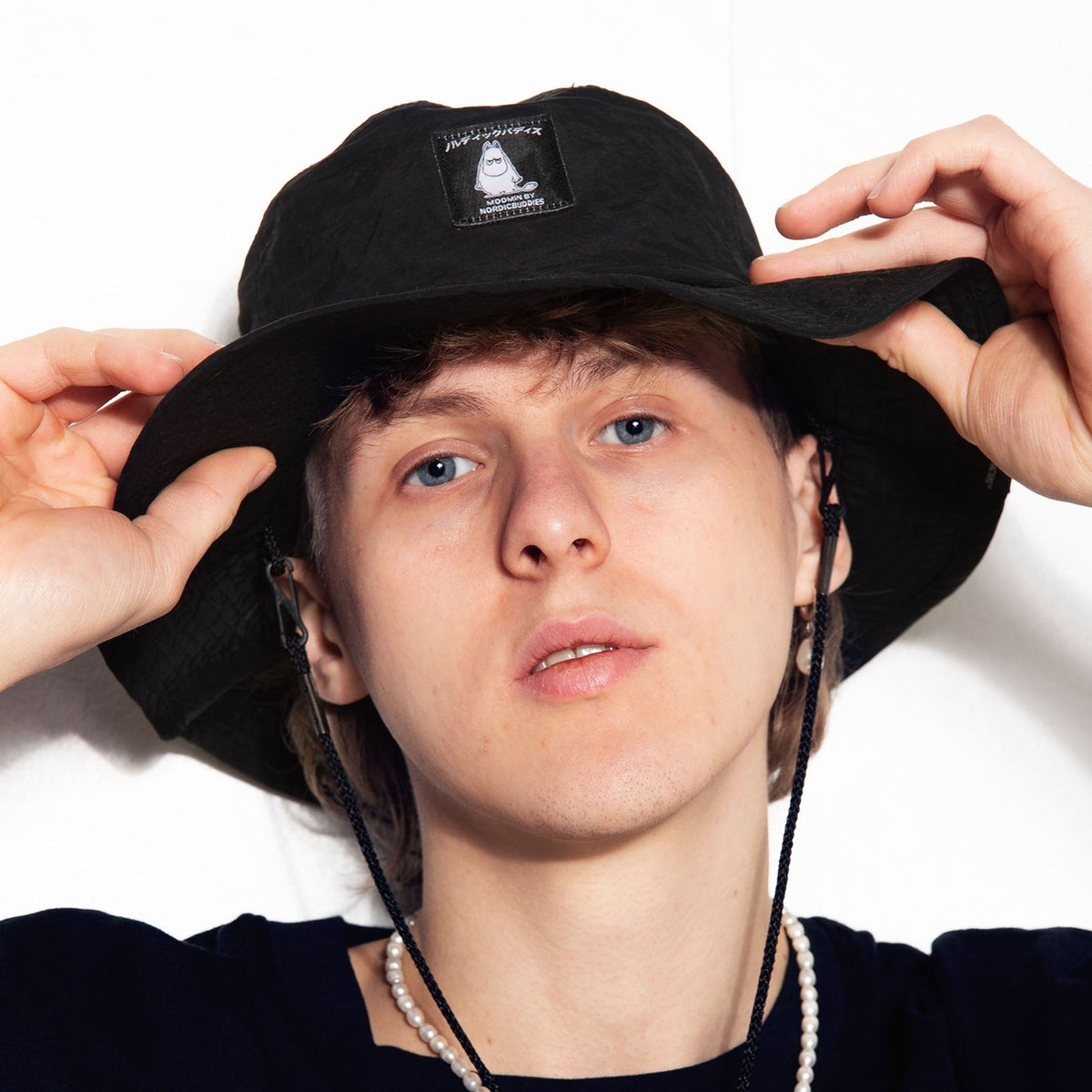 2. Close-up of male model wearing Moomintroll Brimmer Hat in black, highlighting Moomin logo