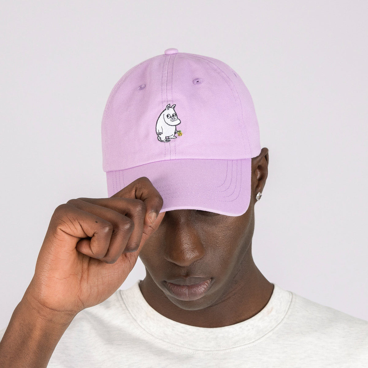 1. Men's Moomintroll Flower Dad Cap in lavender worn by model, featuring Moomin embroidery, studio setting