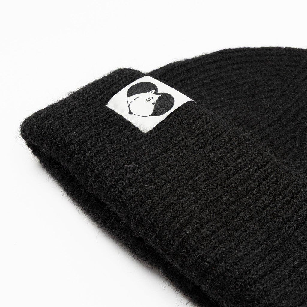 3. Close-up of black Moomintroll beanie showing logo detail on folded brim