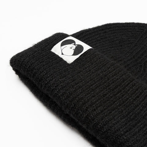 3. Close-up of black Moomintroll beanie showing logo detail on folded brim