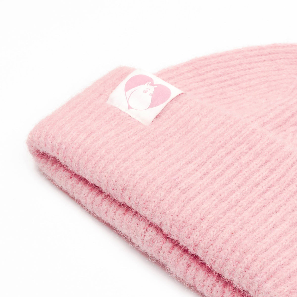 3. Close-up of pink Moomintroll fluffy chunky beanie by NordicBuddies showing logo detail on ribbed fabric