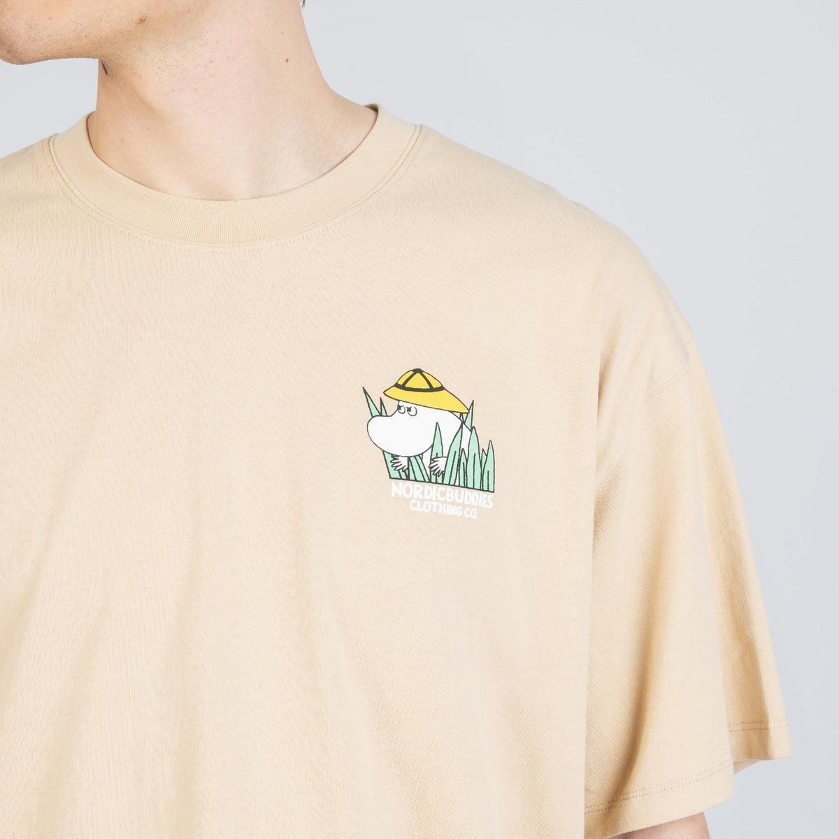 6. Close-up of front logo on beige Moomintroll Jungle T-shirt, featuring Moomin character