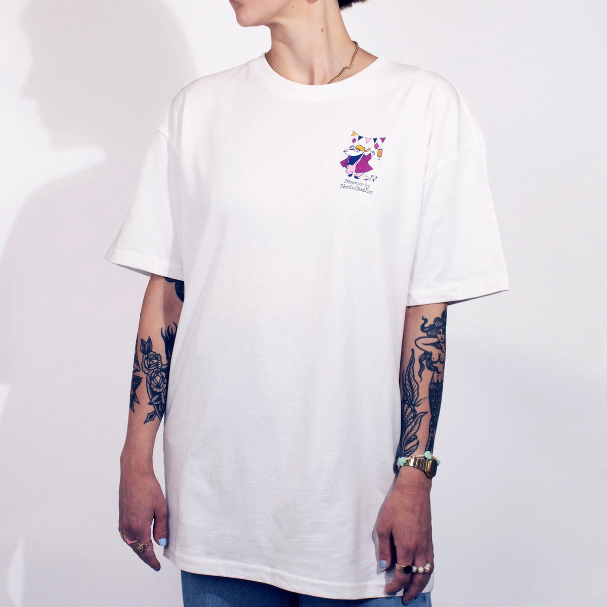 3. Person wearing white unisex Moomin Party T-shirt with small front print, studio setting