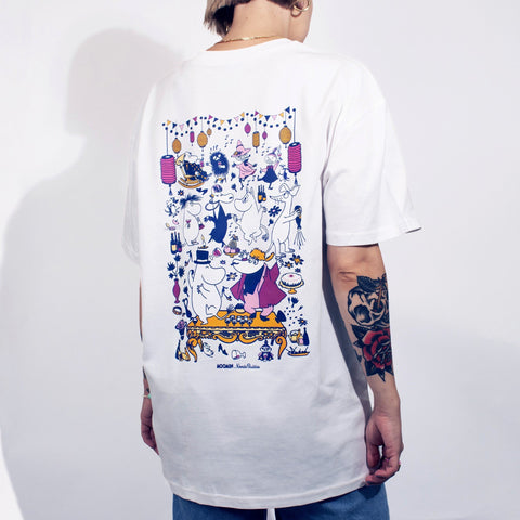 1. Person wearing white unisex Moomin Party T-shirt with colorful back print, standing in studio setting