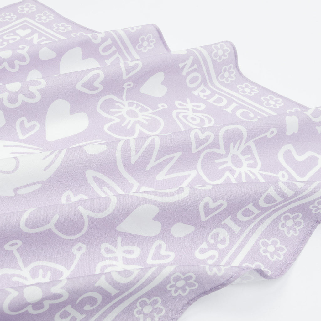 2. Close-up of lilac cotton scarf showing floral and heart patterns with NordicBuddies text border