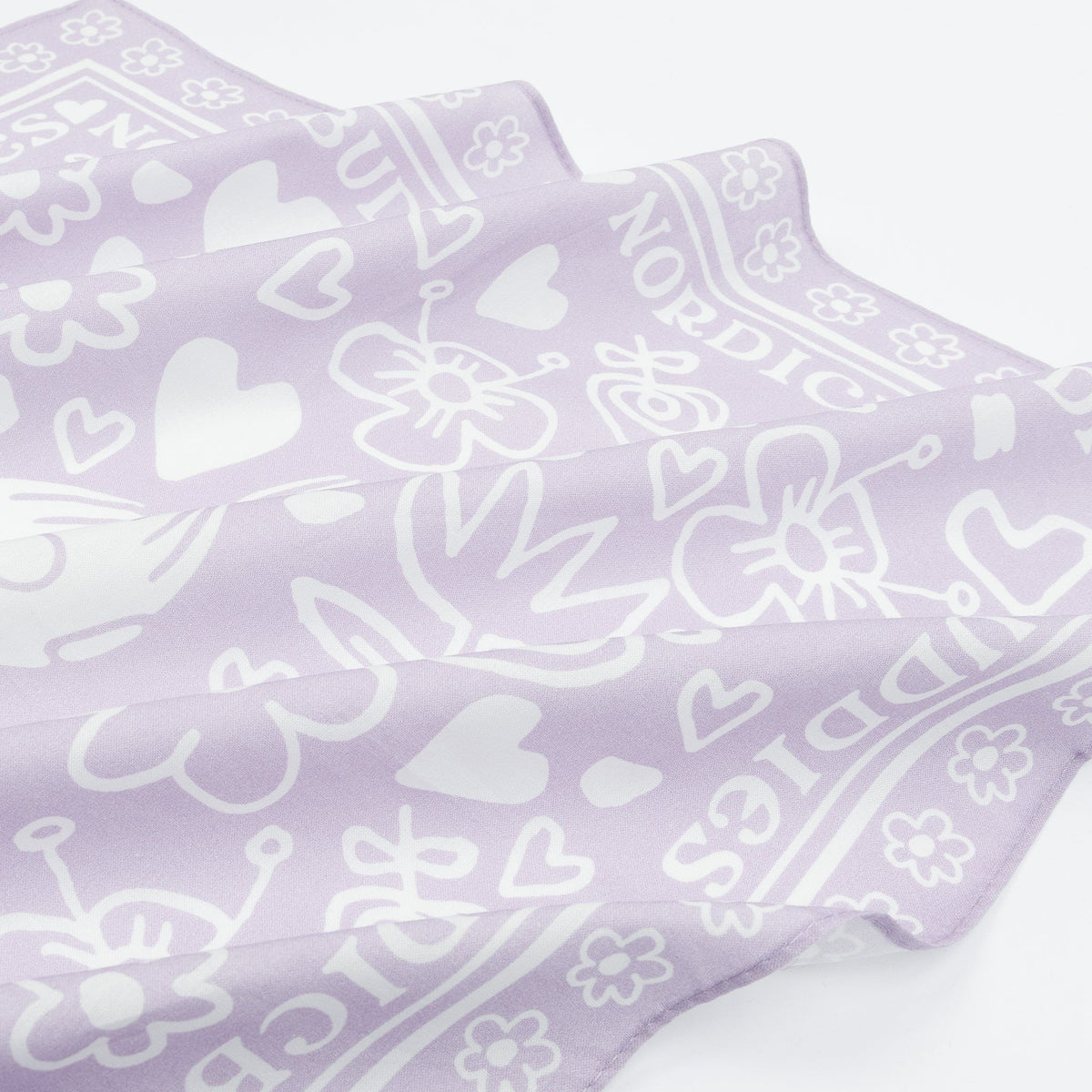 2. Close-up of lilac cotton scarf showing floral and heart patterns with NordicBuddies text border