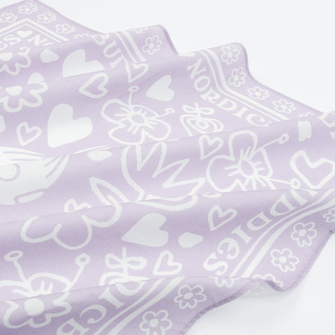 2. Close-up of lilac cotton scarf showing floral and heart patterns with NordicBuddies text border