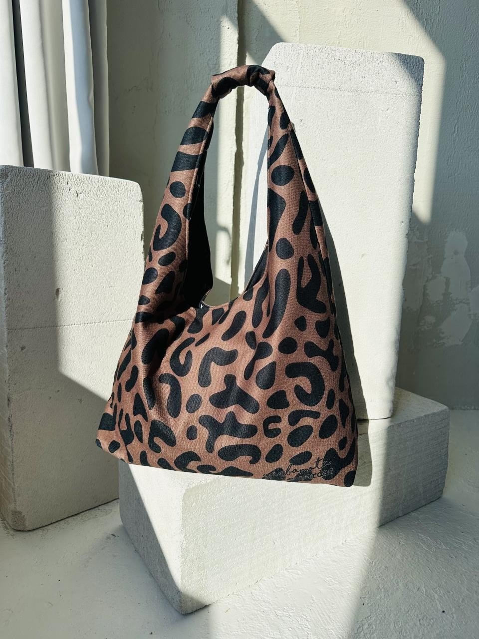 12. Garbanota Moon Bag in classic leopard print, paired with matching scarf on a mannequin head