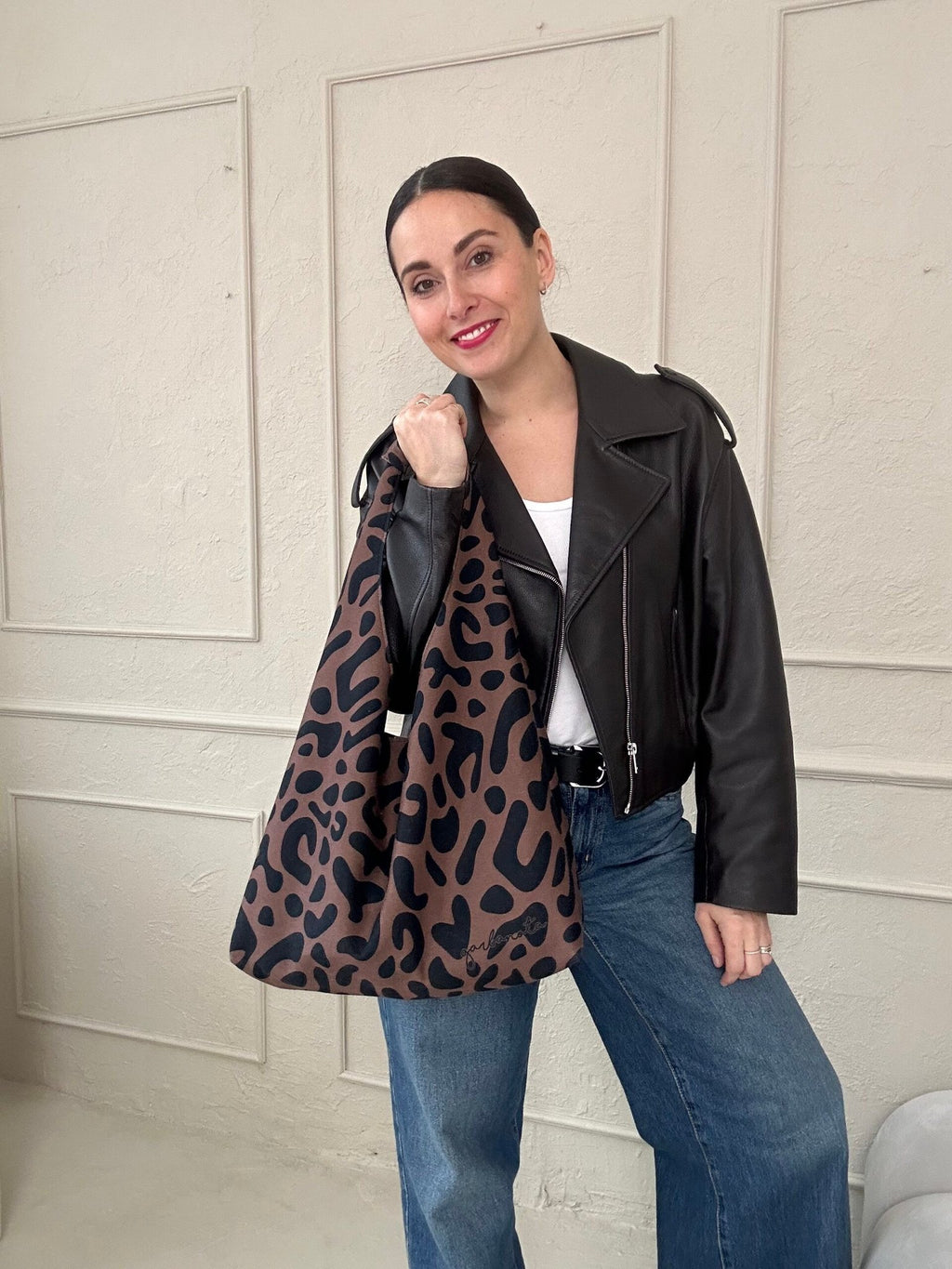 4. Studio shot of Garbanota Moon Bag in classic leopard print, displayed on a white pedestal