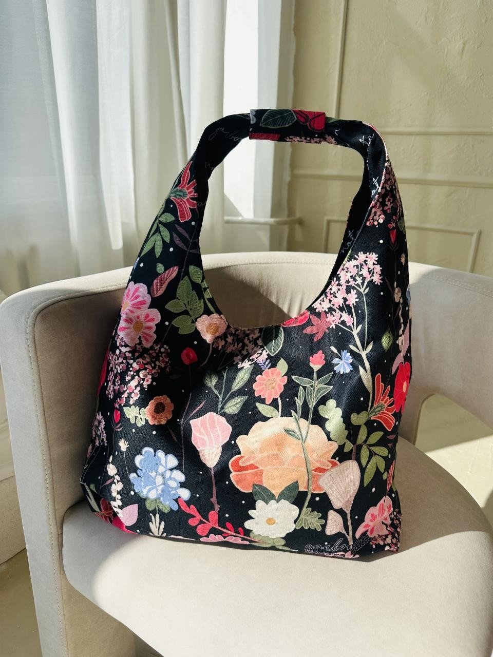 11. Garbanota Moon Bag - Curly Summer Night with floral pattern on beige chair, lifestyle setting